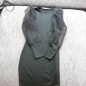 Bodycon black dress with sheer sleeves.